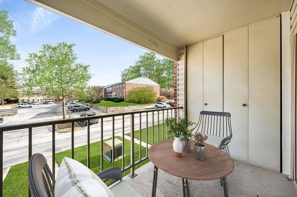 A balcony with a table and chairs overlooking a street.