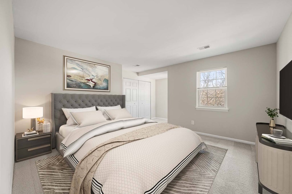 A bedroom with a large bed and a painting on the wall.