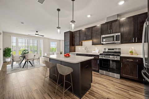 A modern kitchen with dark wood cabinets and a center island.