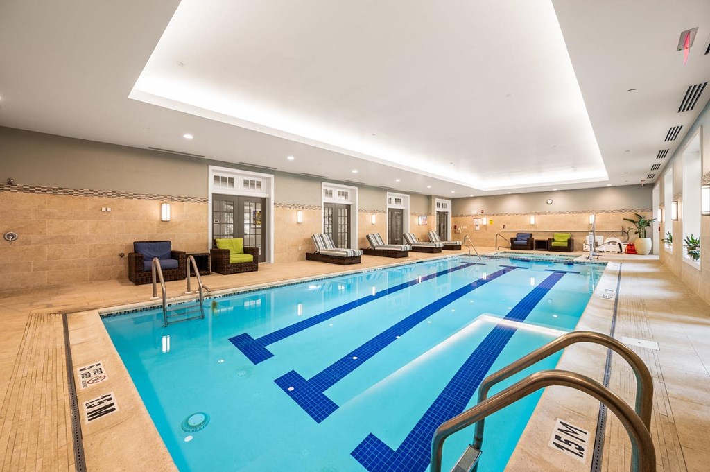 A large indoor swimming pool with blue lanes and a wooden floor.