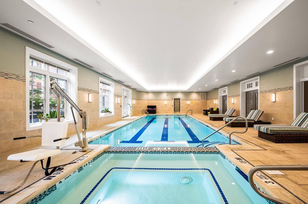A large indoor swimming pool with a diving board and lane markers.
