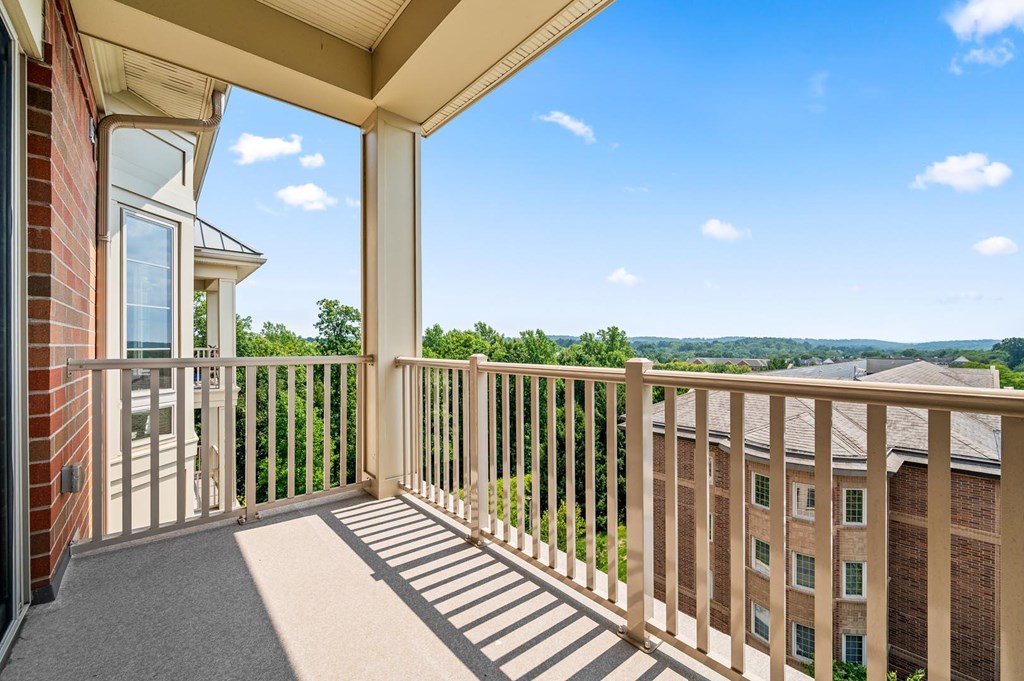 A balcony with a view of the sky and trees.
