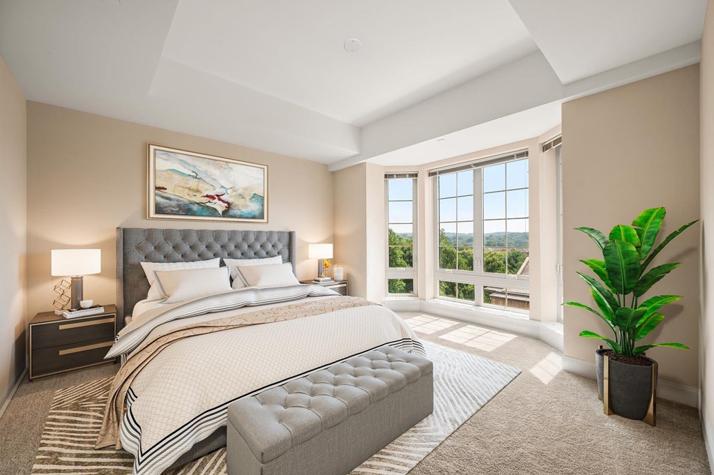 A bedroom with a large bed and a painting on the wall.