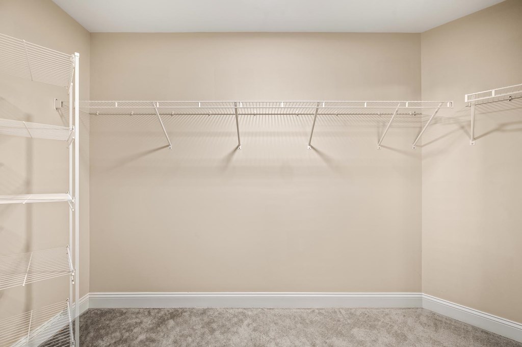 Empty room with a white closet rod and hangers.