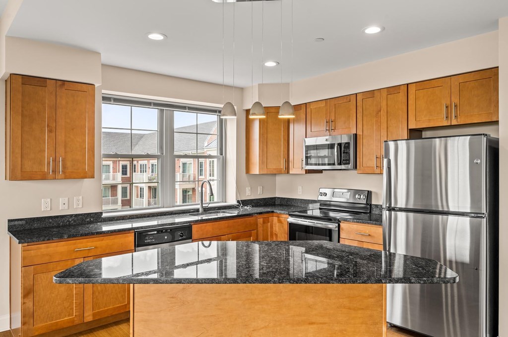 A modern kitchen with wooden cabinets and stainless steel appliances.