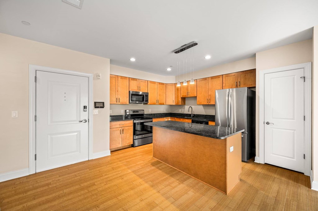 A kitchen with wooden cabinets and a black countertop.