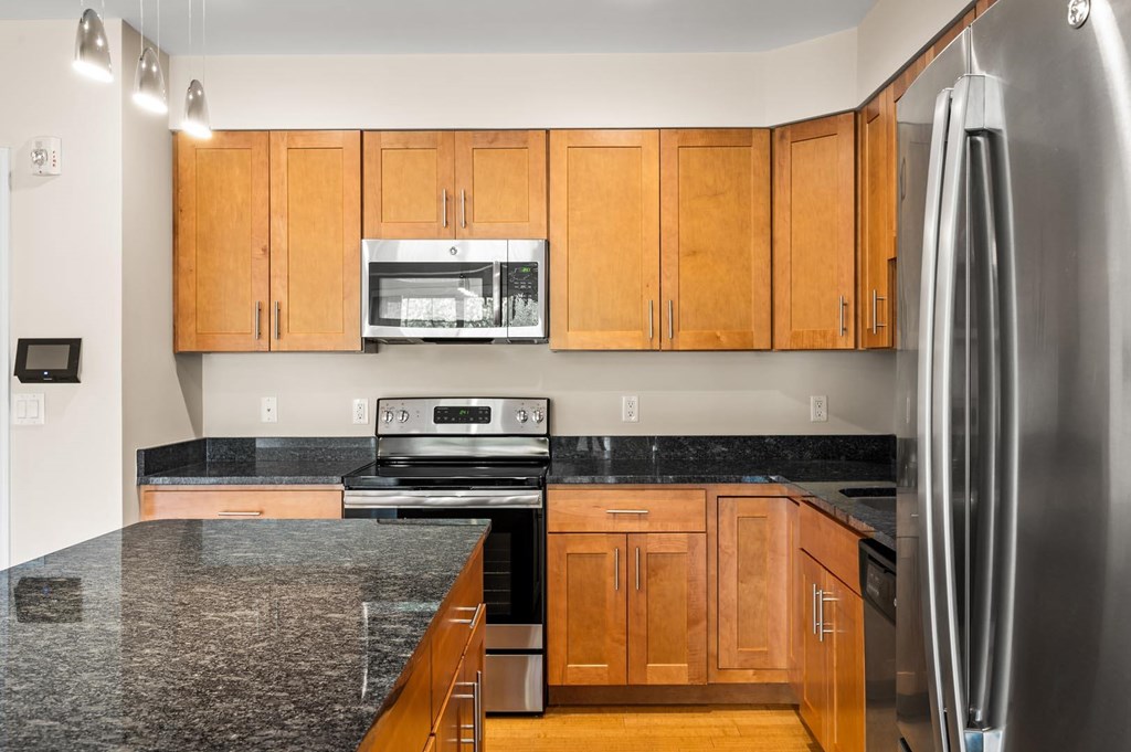 A kitchen with wooden cabinets and granite countertops.