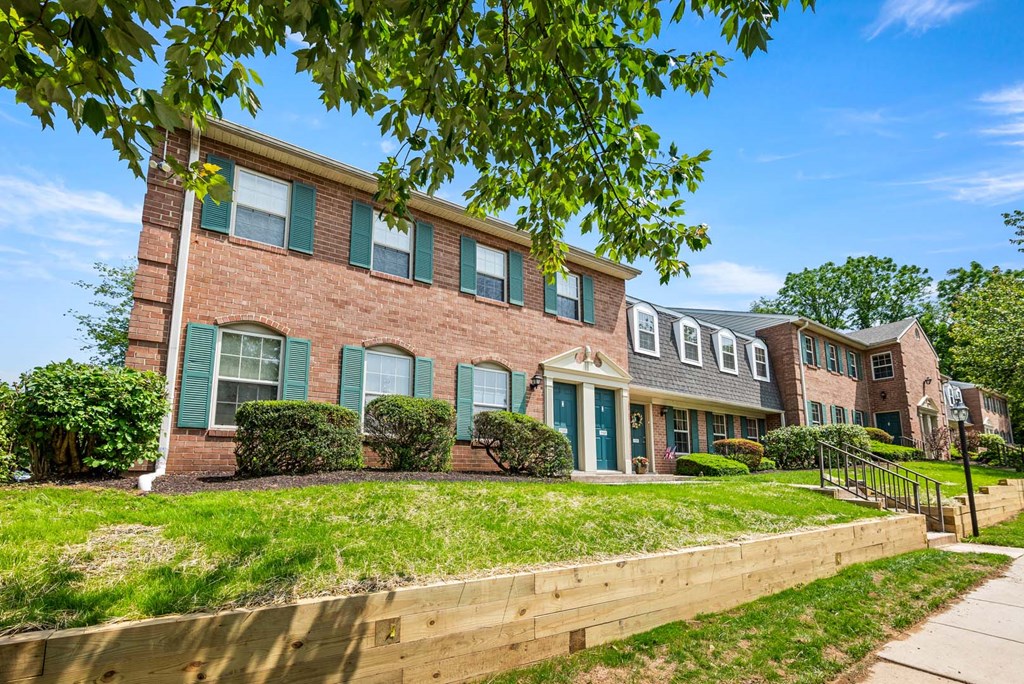 A row of houses with green shutters and a blue sky above.