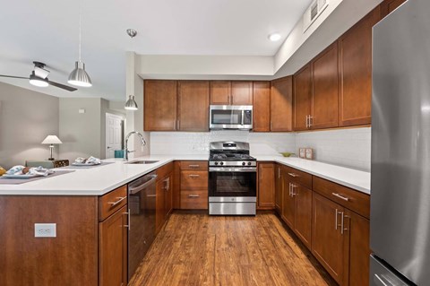 A modern kitchen with wooden cabinets and stainless steel appliances.
