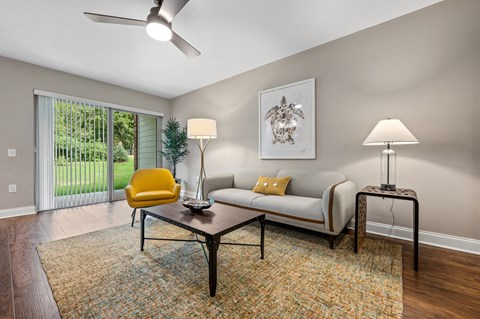 A living room with a yellow chair and a white couch.