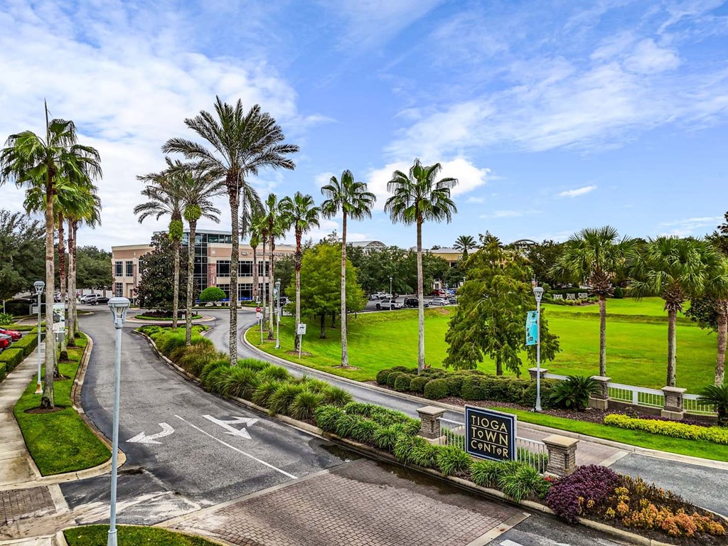 A street view of a campus with palm trees and a sign that says "Logan Center.".