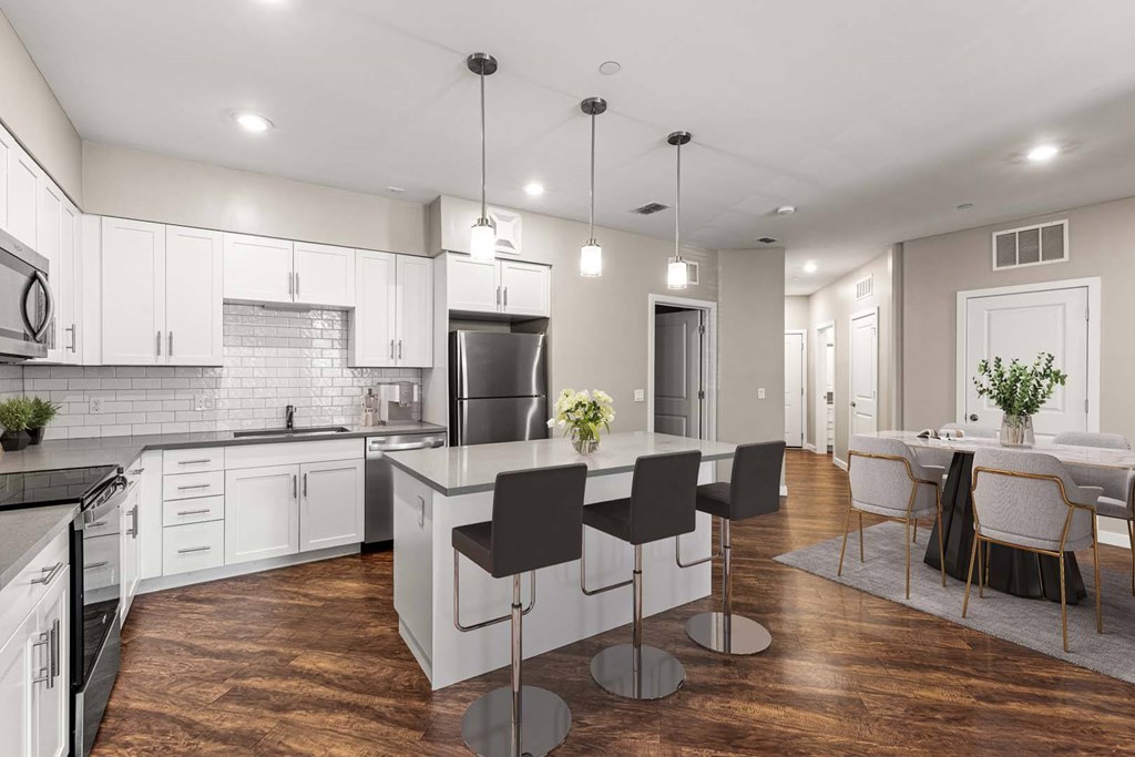 A modern kitchen with a central island and bar stools.