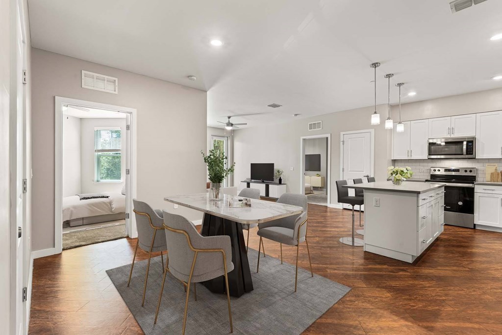 A modern kitchen with a dining table and chairs in the foreground.