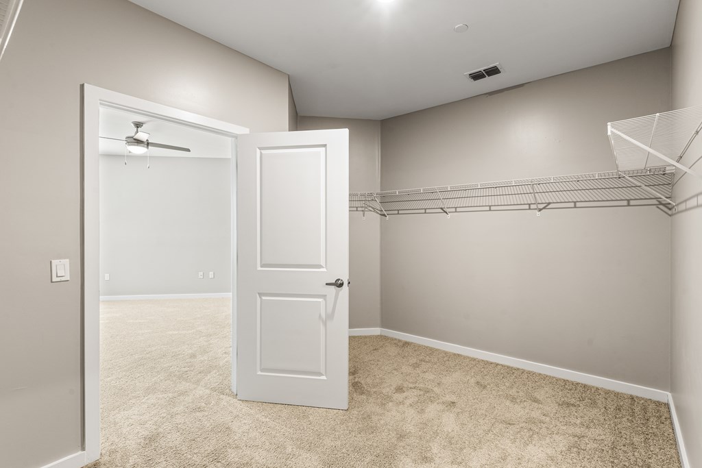 A room with a carpeted floor and two white doors.