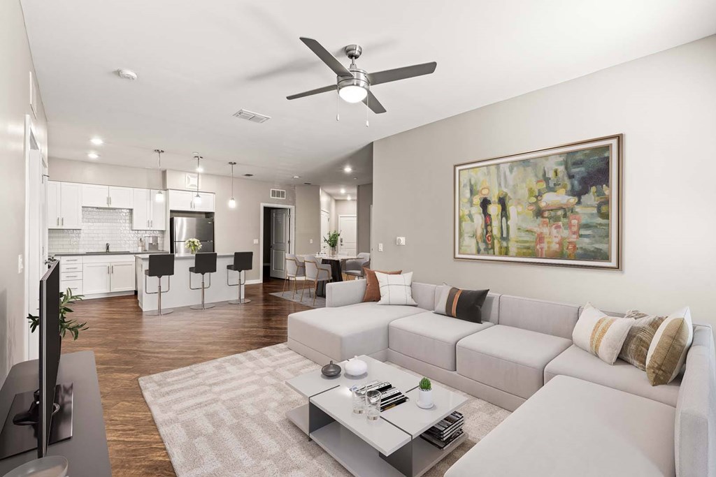 A living room with a grey sofa and a painting on the wall.