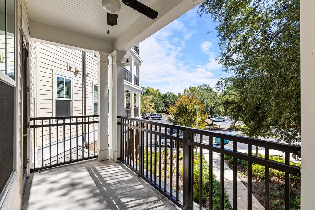 A balcony with a black railing and a white wall.