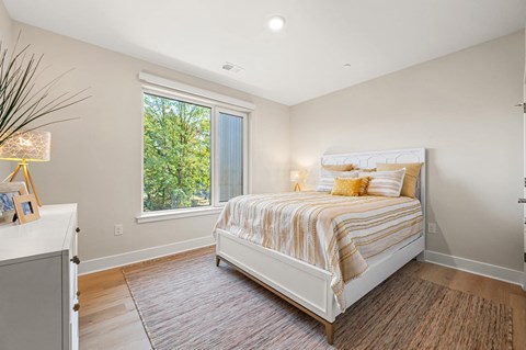 Cozy bedroom featuring a comfortable bed and a large window allowing natural light at Hamilton at Eagleview in Exton, PA