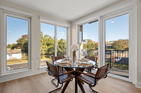 Bright dining area with large windows, a stylish table, and modern seating at Hamilton at Eagleview in Exton, PA