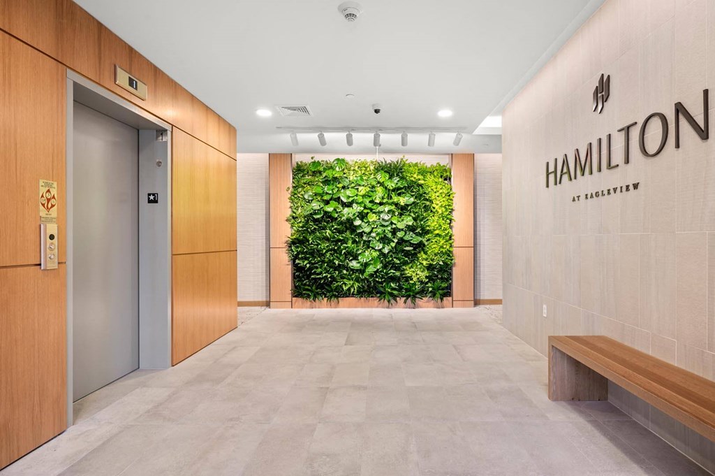 Hotel lobby featuring a striking large green wall in the background, creating a vibrant and welcoming atmosphere