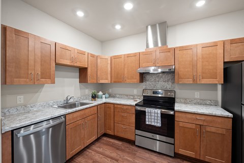 an empty kitchen with wooden cabinets and stainless steel appliances