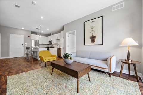 A living room with a yellow chair and a white couch.