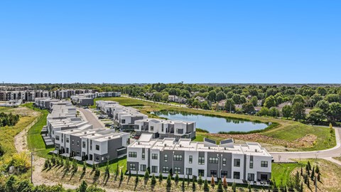 an aerial view of apartment buildings next to a lake