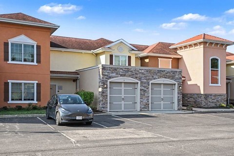 A Tesla car is parked in front of a house.