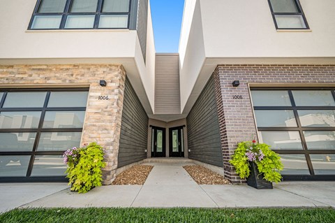 a view of the entrance to a building with windows and a sidewalk