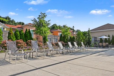 A row of chairs are lined up on a patio.