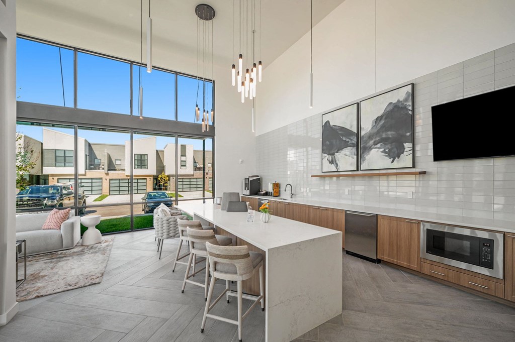 a kitchen with a white counter top and a large window  at Signature at West Pryor, Lee's Summit