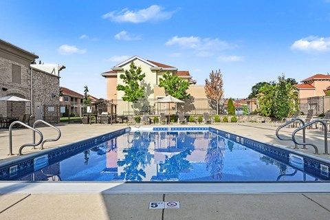 A swimming pool with a blue tiled edge and a white sign that says 5'.