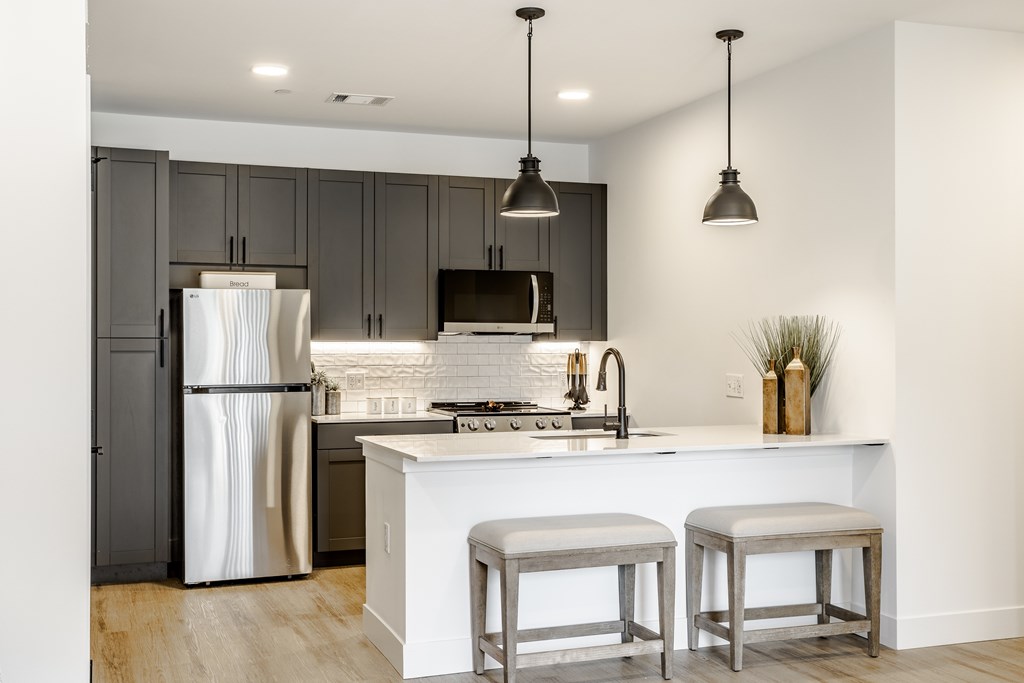 A modern kitchen with a white island and stainless steel appliances.