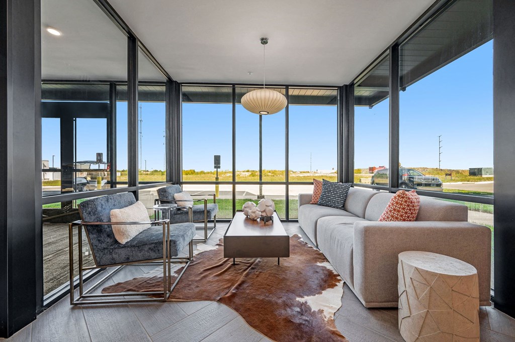 a living room with a couch and a coffee table in front of windows  at Signature at West Pryor, Lee's Summit, MO