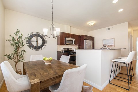 A kitchen with a wooden table and white chairs.