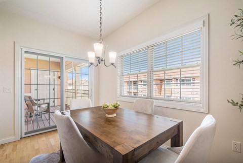 Dining room on wooden floors with table and chairs overlooking patio at The Residences at Toscana Park, Granger