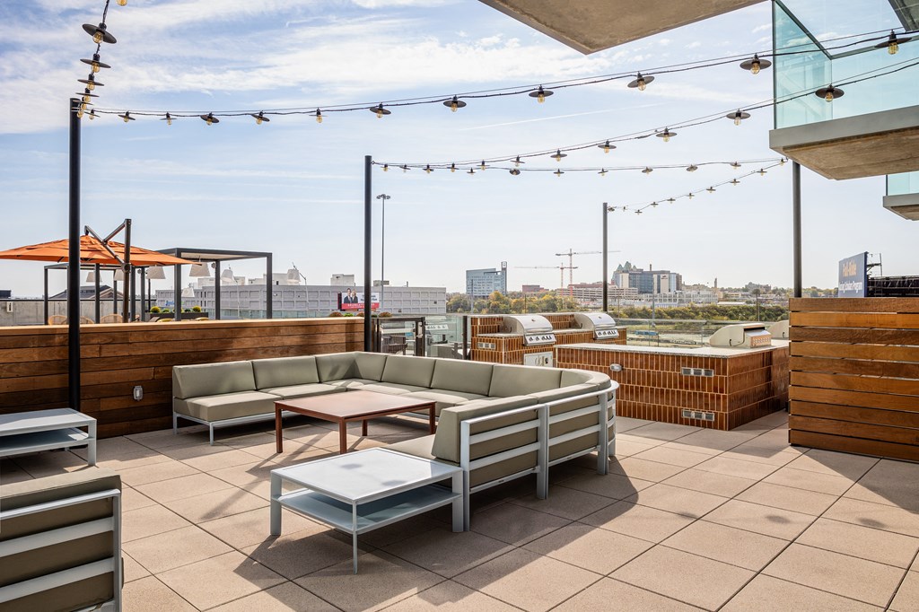 A patio with a table and chairs overlooking a cityscape. at One Foundry Way Apartments, St Louis, 63110