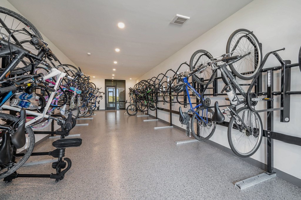 a room with several bikes hanging on racks on the wall  at Signature at West Pryor, Lee's Summit, MO