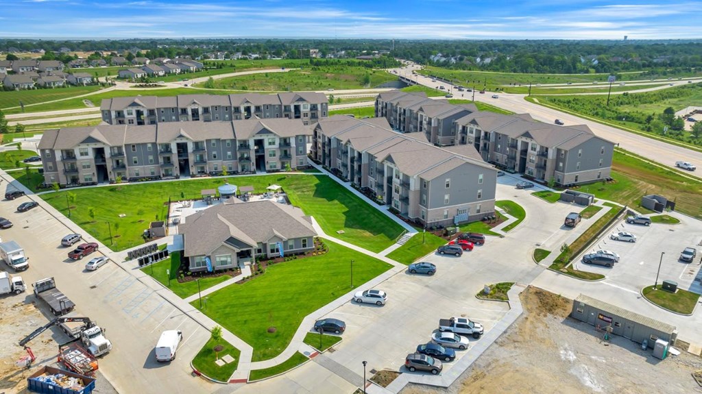 an aerial view of an apartment complex with cars parked in a parking lot at The Prairie Luxury Apartments, Dardenne Prairie, MO 63368