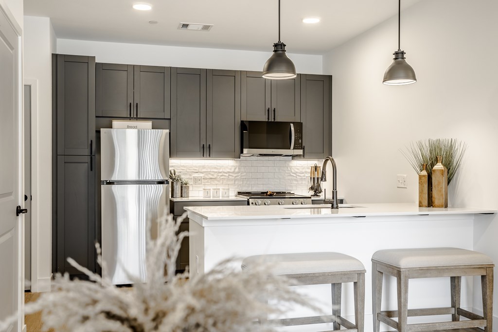 A kitchen with a white refrigerator and a white countertop.