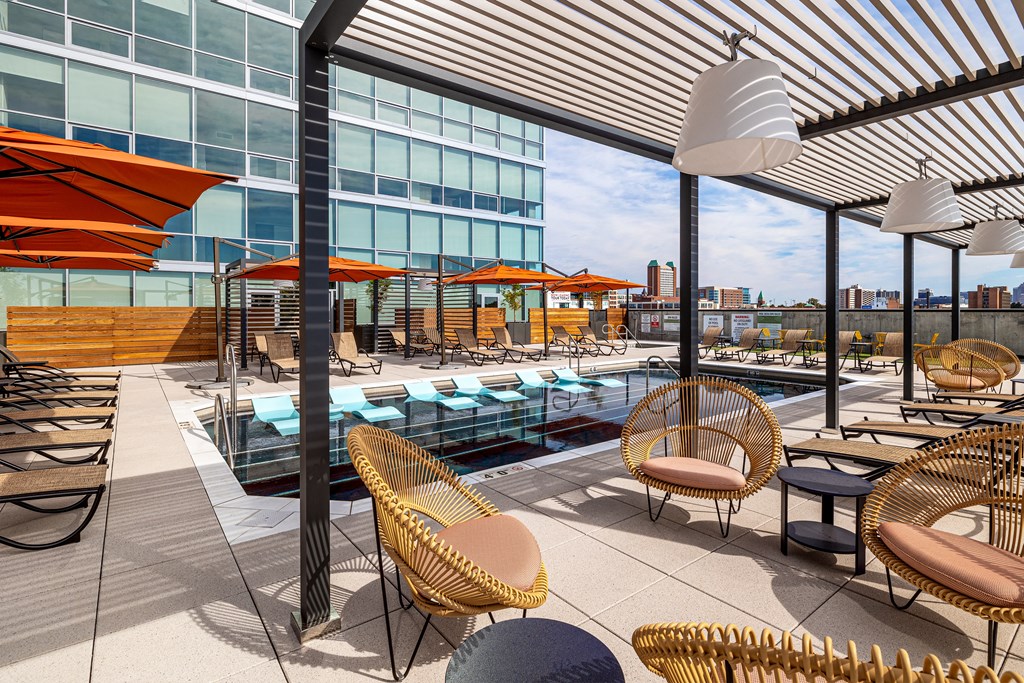 A rooftop patio with a pool and chairs. at One Foundry Way Apartments, St Louis