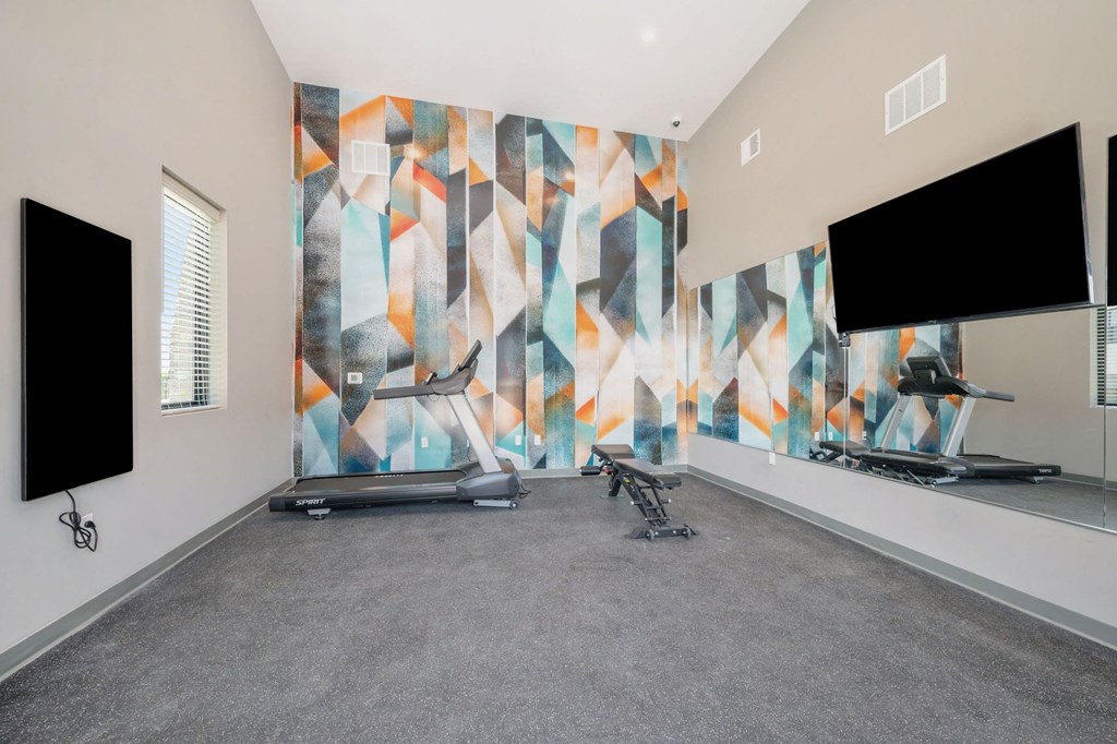 a workout room with a large graphic of the wordrupel on the wall  at Signature at West Pryor, Lee's Summit, Missouri