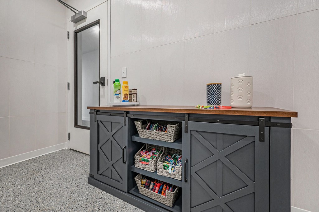 a kitchen with a counter top and a cabinet with shelves  at Signature at West Pryor, Lee's Summit, Missouri