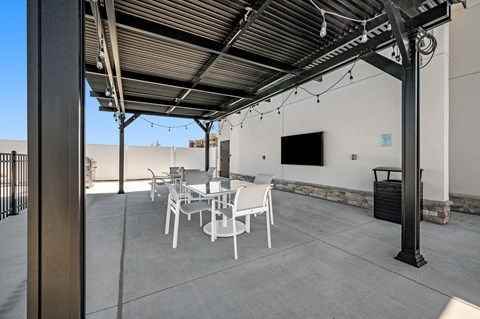 a patio with tables and chairs and a tv on the wall
