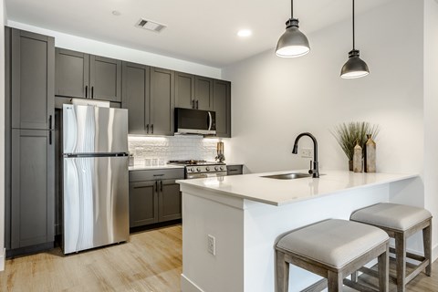 A modern kitchen with a stainless steel refrigerator and a white countertop.