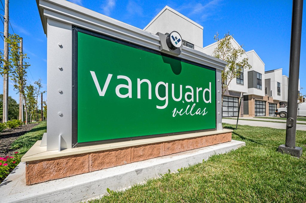 a sign for vanguard villas with a building in the background