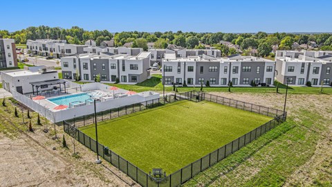 an aerial view of an apartment complex with a soccer field and a pool