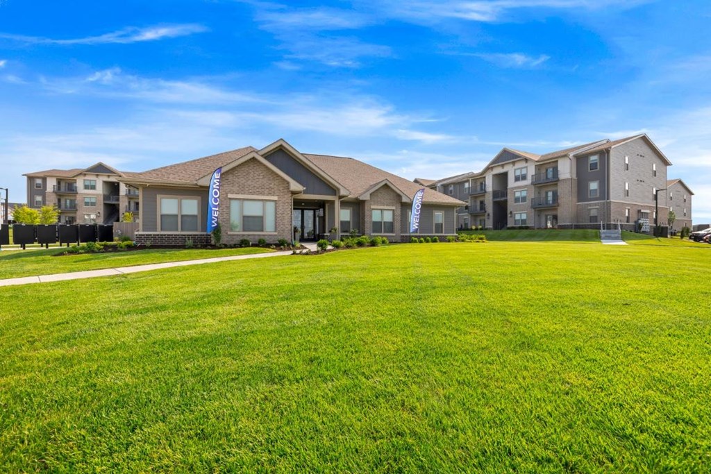 a large green lawn in front of an apartment building at The Prairie Luxury Apartments, Dardenne Prairie, MO