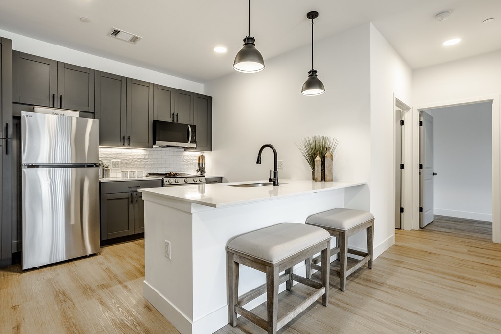 A modern kitchen with a white island and stainless steel appliances.