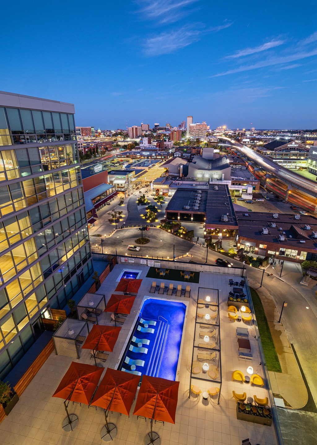 A rooftop pool area with a view of the city at dusk. at One Foundry Way Apartments, St Louis, 63110