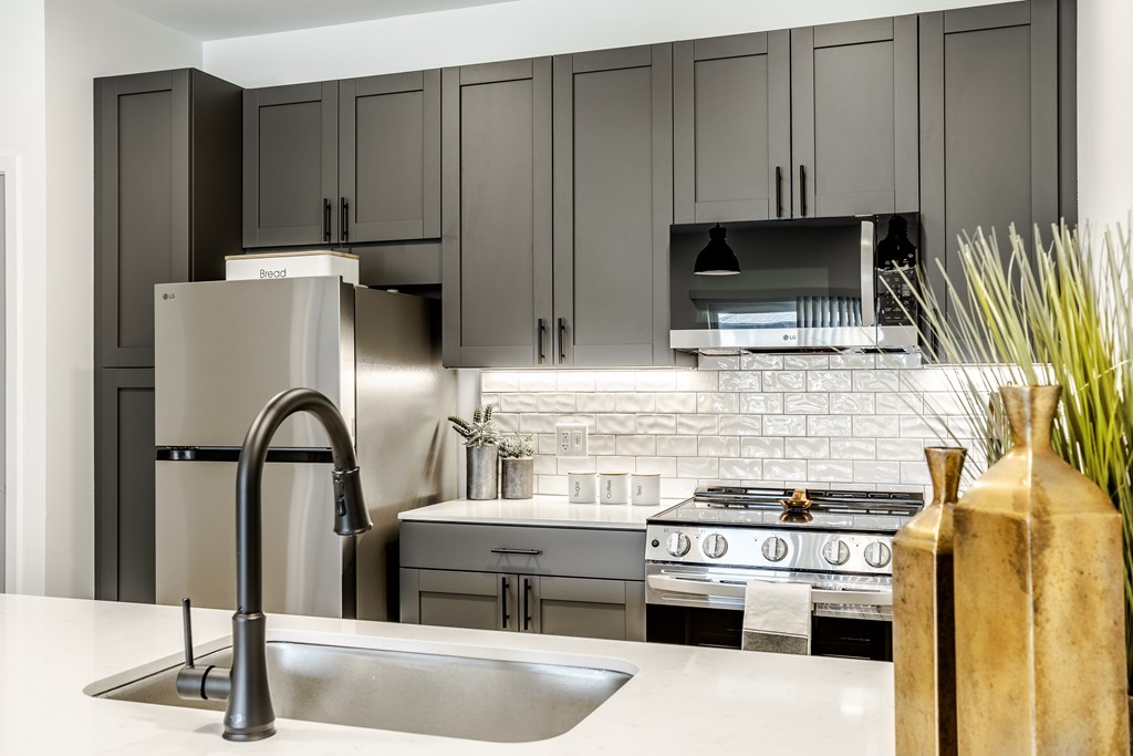 A modern kitchen with a stainless steel refrigerator and a white countertop.